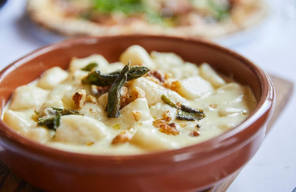 Homemade gnocchi in gorgonzola sauce with burnt butter, walnuts and sage
